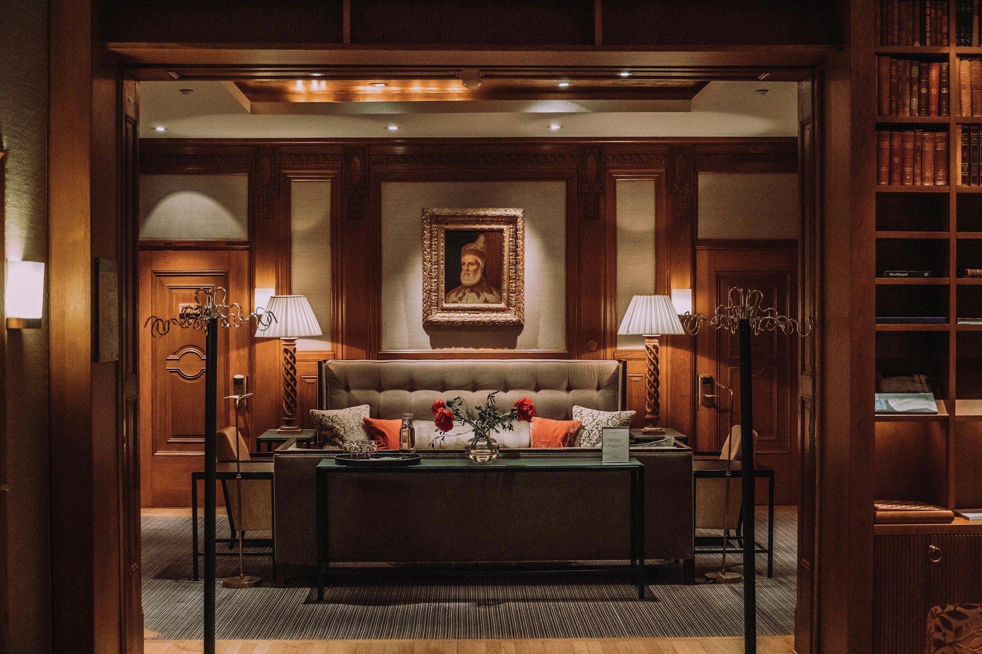 A wood-panelled grand-hotel salon in low warm light